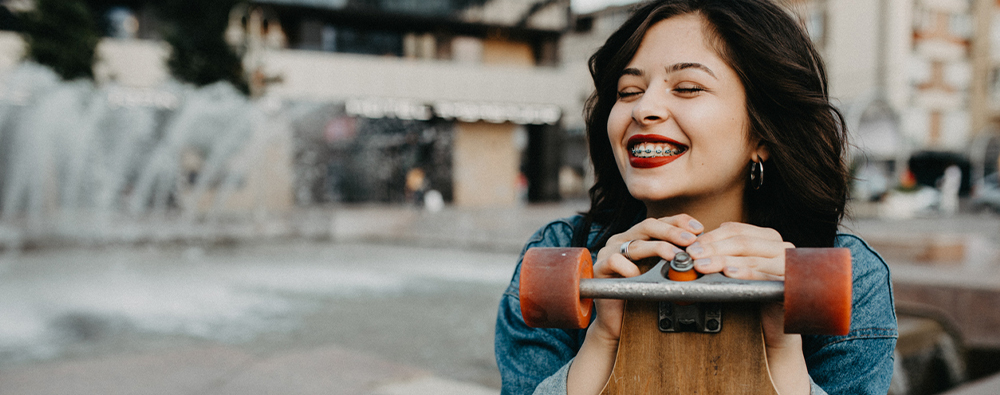 Female skateboarder smiling with braces. 