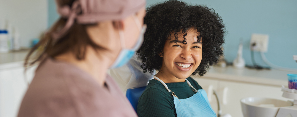 Young black woman smiling at her dental hygienist.