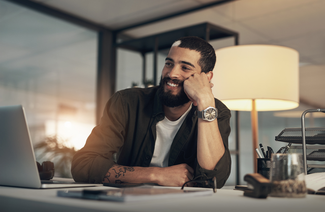 Man smiling while sitting at a desk