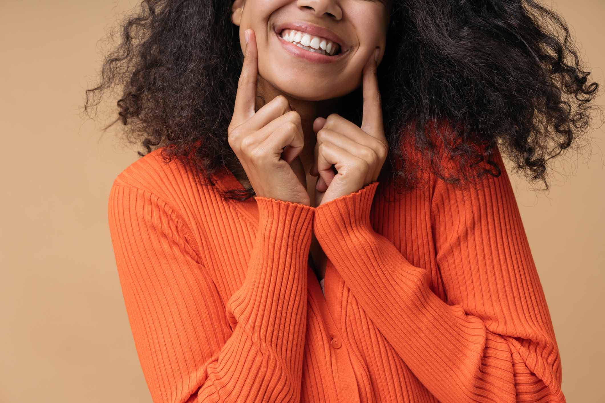 Girl in orange sweater smiling